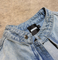 Close-up of a denim jacket with a brand label on a beige background