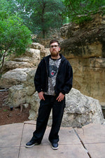 Man standing outdoors in front of rocky landscape